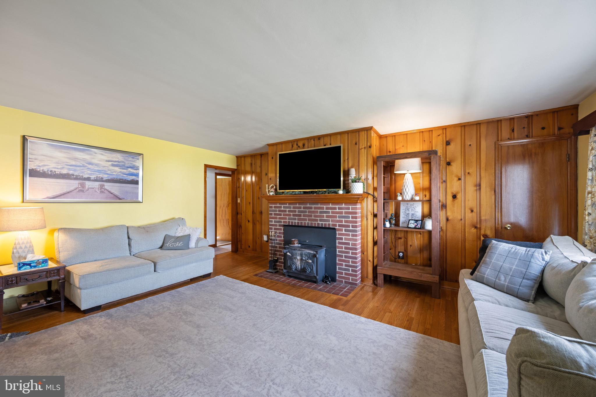 4207 Ralph Avenue Hampstead, MD 21074 - Photo 11 of 33 a living room with furniture a fireplace and a flat screen tv