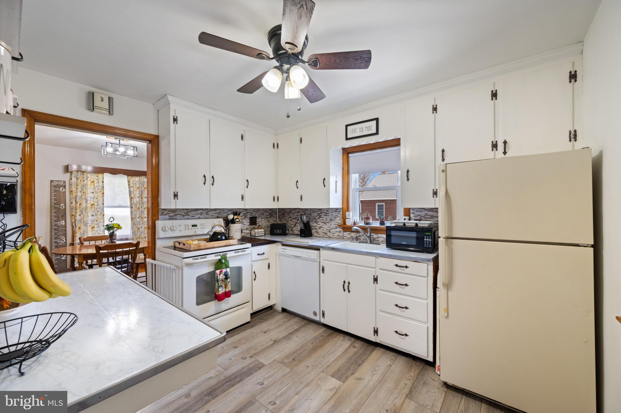 4207 Ralph Avenue Hampstead, MD 21074 - Photo 8 of 33 a kitchen with stainless steel appliances white cabinets and wooden floor