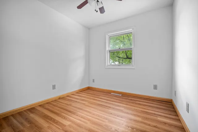 a view of a room with wooden floor and window