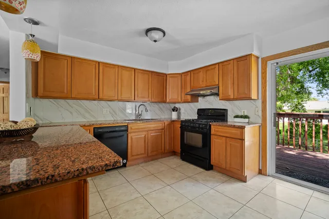 a kitchen with granite countertop a sink and a stove top oven