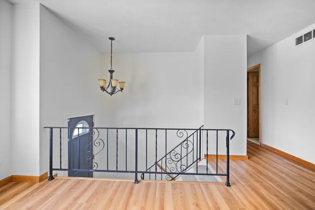 a view of a hallway with wooden floor and staircase