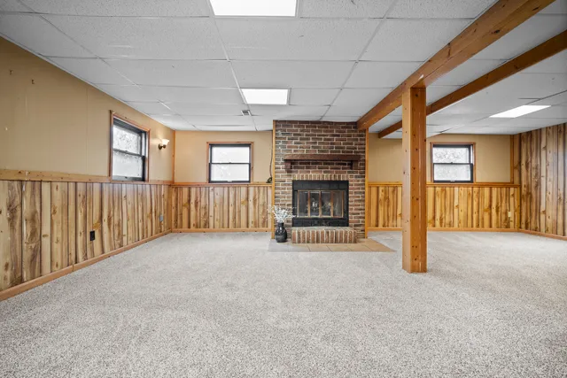 a view of an empty room with a fireplace and a window