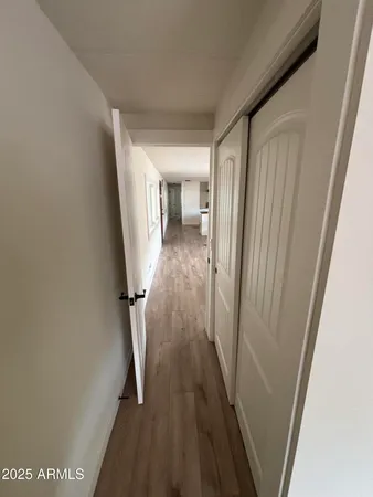 a view of a hallway with wooden floor and staircase