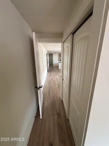 a view of a hallway with wooden floor and staircase