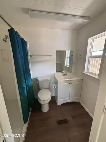 a white toilet sitting next to a bathroom sink and a mirror