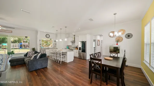 a living room with furniture a wooden floor and a chandelier