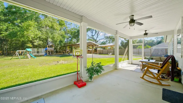 a view of a patio with table and chairs and floor to ceiling window