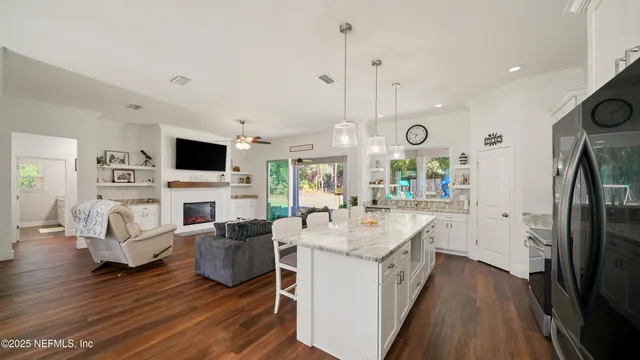 a large white kitchen with sink and stainless steel appliances