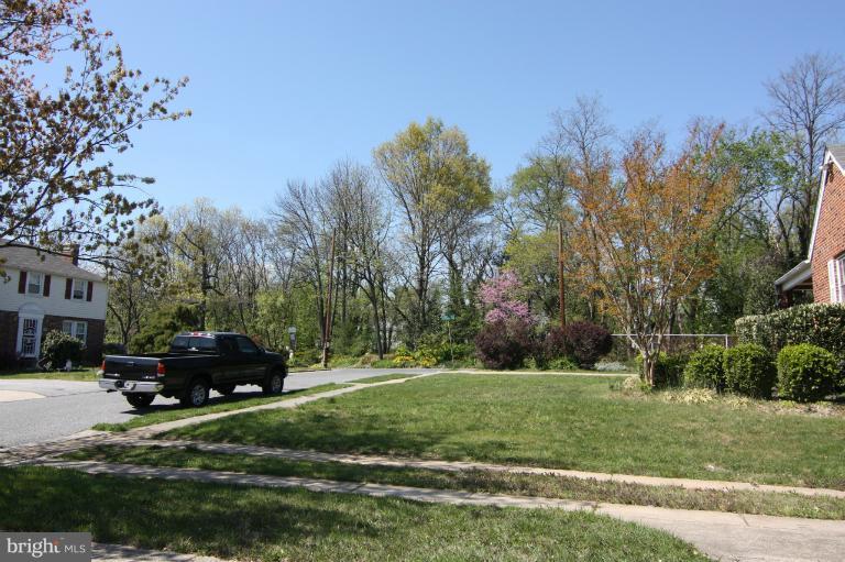 703 Dorchester Road Baltimore, MD 21229 - Photo 24 of 27 a front view of a house with a garden and trees
