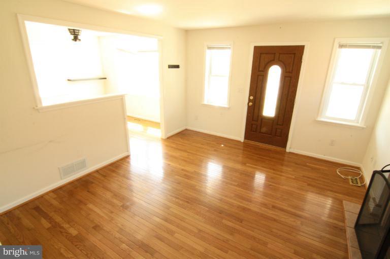 703 Dorchester Road Baltimore, MD 21229 - Photo 25 of 27 a view of an empty room with wooden floor and a window
