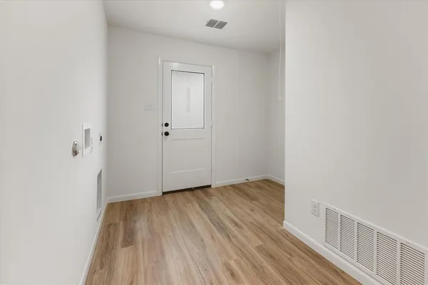 a view of an empty room with wooden floor