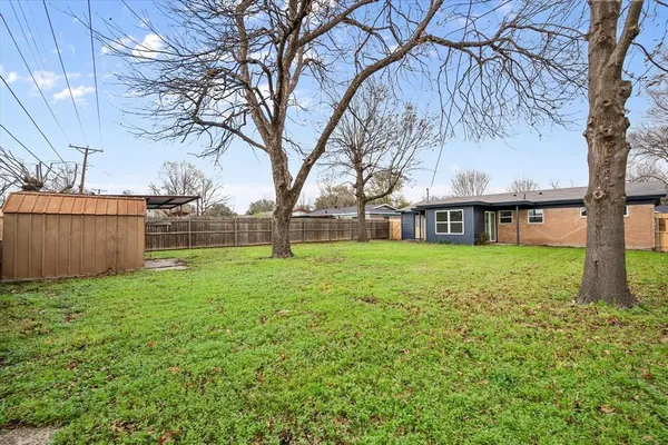 a view of a house with backyard and a tree