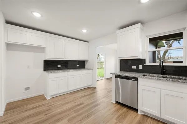 a kitchen with a sink a microwave and cabinets