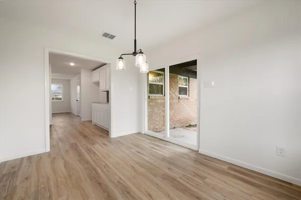 a view of a room with wooden floor and a ceiling fan