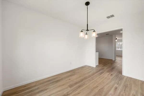 a view of a room with wooden floor and ceiling fan