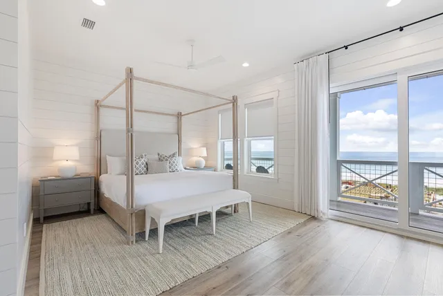 a living room with furniture a large window and a potted plant