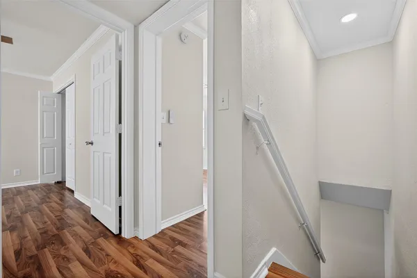 a view of a hallway with wooden floor and entryway