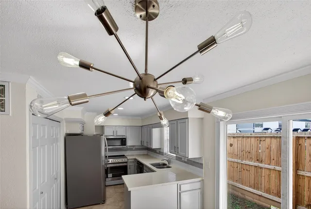 a kitchen with stainless steel appliances kitchen island granite countertop a refrigerator a stove and a sink with wooden floor