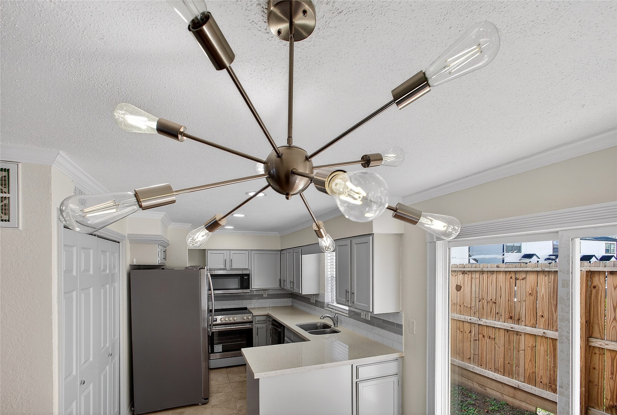 1221 Cedar Post Lane, Unit 1B Houston, TX 77055 - Photo 21 of 23 a kitchen with stainless steel appliances kitchen island granite countertop a refrigerator a stove and a sink with wooden floor