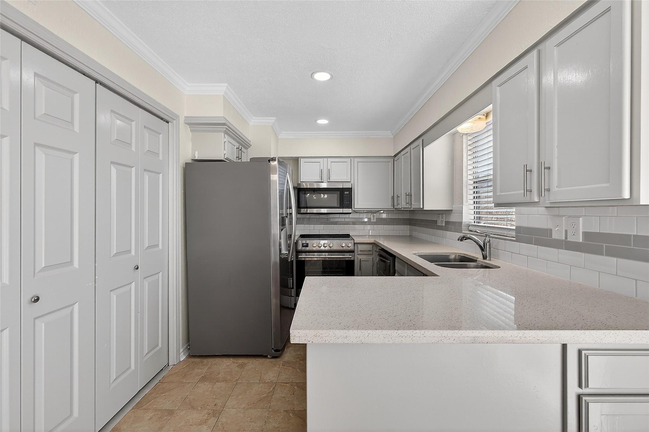 1221 Cedar Post Lane, Unit 1B Houston, TX 77055 - Photo 6 of 23 a kitchen with a refrigerator a sink and cabinets