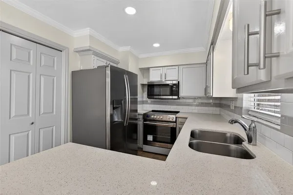 a kitchen with stainless steel appliances granite countertop a refrigerator sink and stove