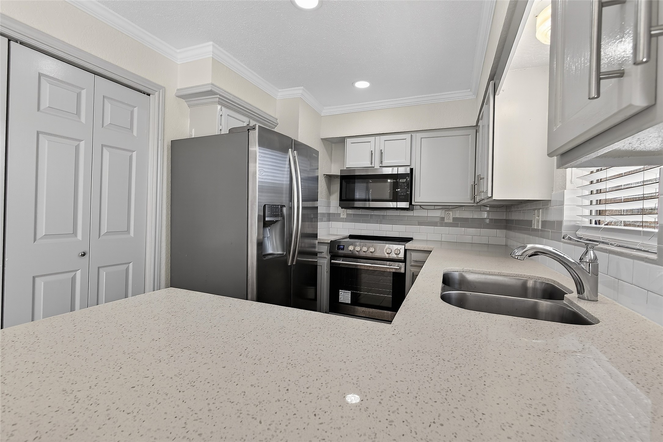 1221 Cedar Post Lane, Unit 1B Houston, TX 77055 - Photo 9 of 23 a kitchen with granite countertop a refrigerator a sink a stove a microwave and wooden cabinets