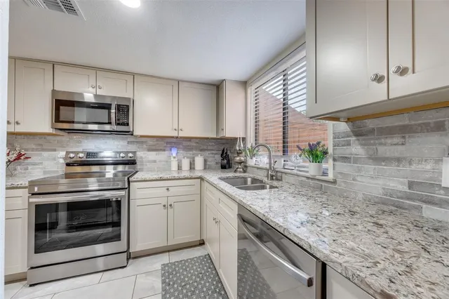 a kitchen with granite countertop cabinets stainless steel appliances and a sink