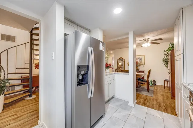 a room with stainless steel appliances a refrigerator and cabinets