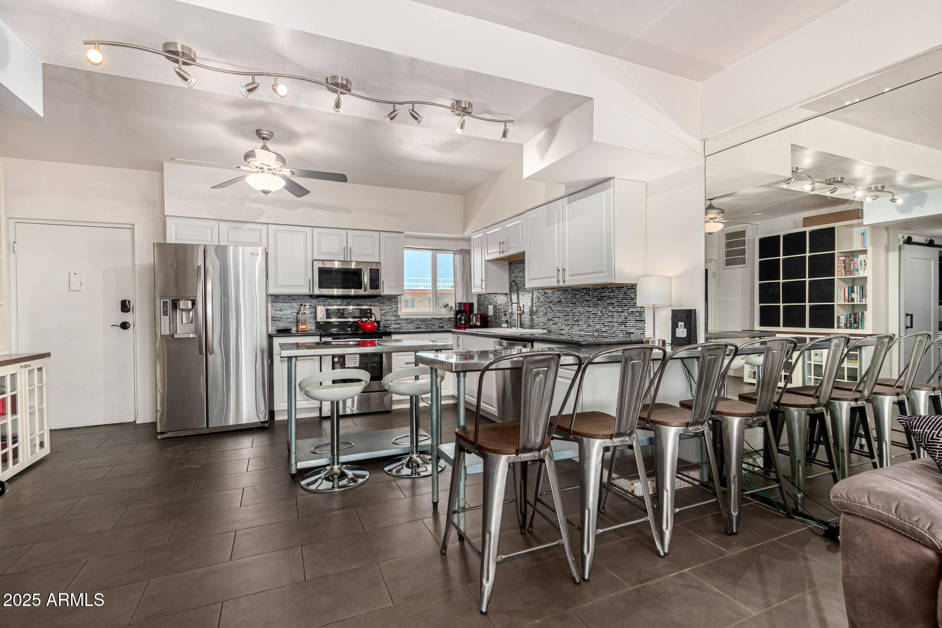 351 East Thomas Road, Unit D505 Phoenix, AZ 85012 - Photo 8 of 28 a kitchen with stainless steel appliances kitchen island granite countertop a table chairs sink and cabinets