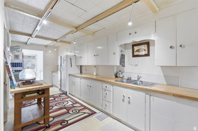 365 North Main Street Fillmore, UT 84631 - Photo 21 of 51 Bright kitchen featuring extensive white cabinetry, wood-finish countertops, and a dual basin stainless steel sink