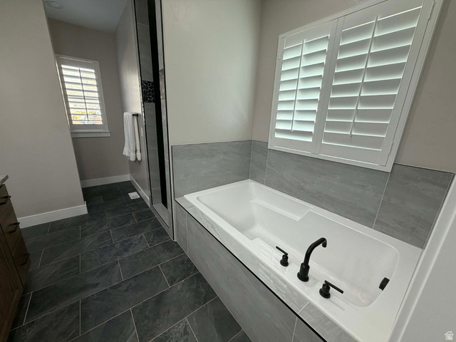 2350 North 1075 West Helper, UT 84526 - Photo 16 of 49 Bathroom with a garden tub, dark tile patterned floors, a stall shower, and vanity