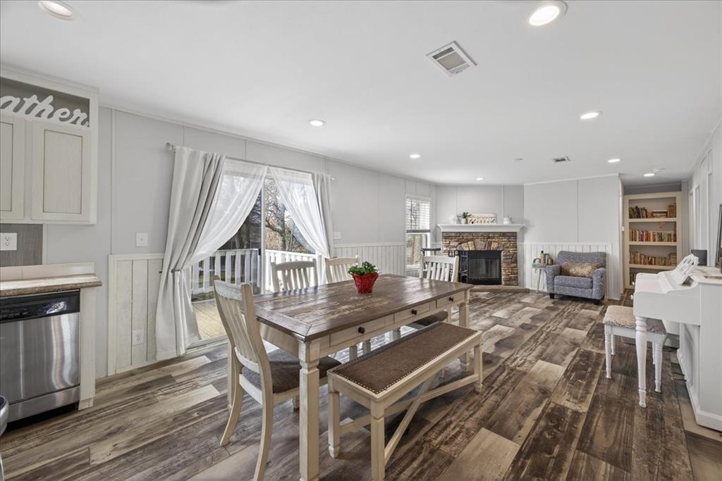 3605 Mockingbird Circle Cleburne, TX 76031 - Photo 18 of 40 Dining area with a stone fireplace, a decorative wall, dark wood-type flooring, and recessed lighting