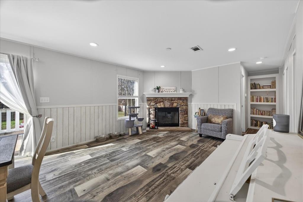 3605 Mockingbird Circle Cleburne, TX 76031 - Photo 20 of 40 Living room with a fireplace, dark wood-style flooring, a decorative wall, recessed lighting, and wainscoting