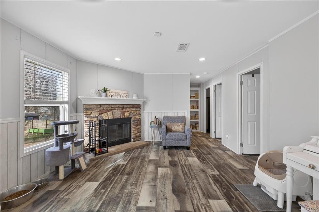 3605 Mockingbird Circle Cleburne, TX 76031 - Photo 21 of 40 Sitting room with dark wood finished floors, a fireplace, a decorative wall, recessed lighting, and ornamental molding