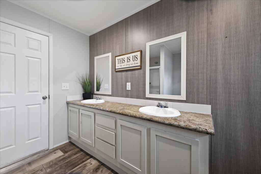 3605 Mockingbird Circle Cleburne, TX 76031 - Photo 25 of 40 Full bathroom featuring double vanity, dark wood-style floors, wallpapered walls, and ornamental molding