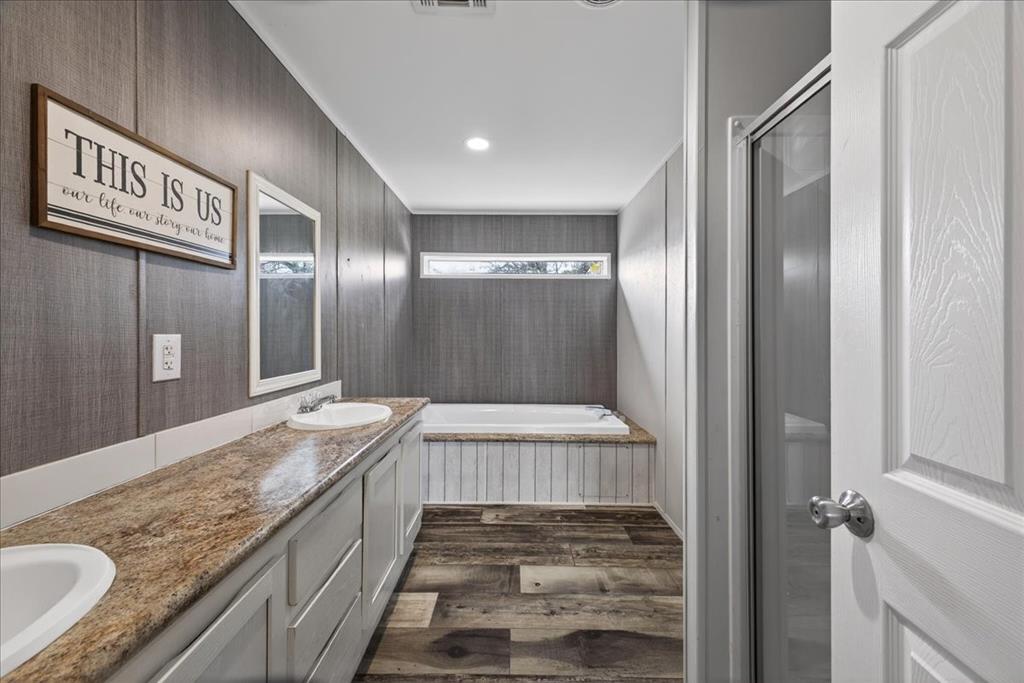 3605 Mockingbird Circle Cleburne, TX 76031 - Photo 27 of 40 Full bath featuring double vanity, a bath, dark wood finished floors, and a stall shower