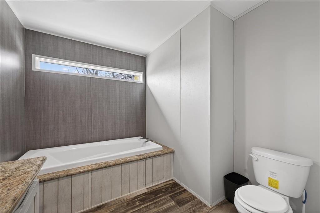 3605 Mockingbird Circle Cleburne, TX 76031 - Photo 28 of 40 Bathroom with a garden tub, dark wood finished floors, and vanity