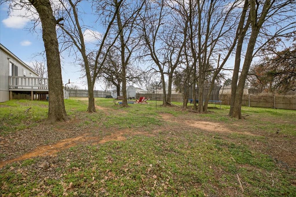 3605 Mockingbird Circle Cleburne, TX 76031 - Photo 38 of 40 Fenced backyard with a trampoline and a wooden deck