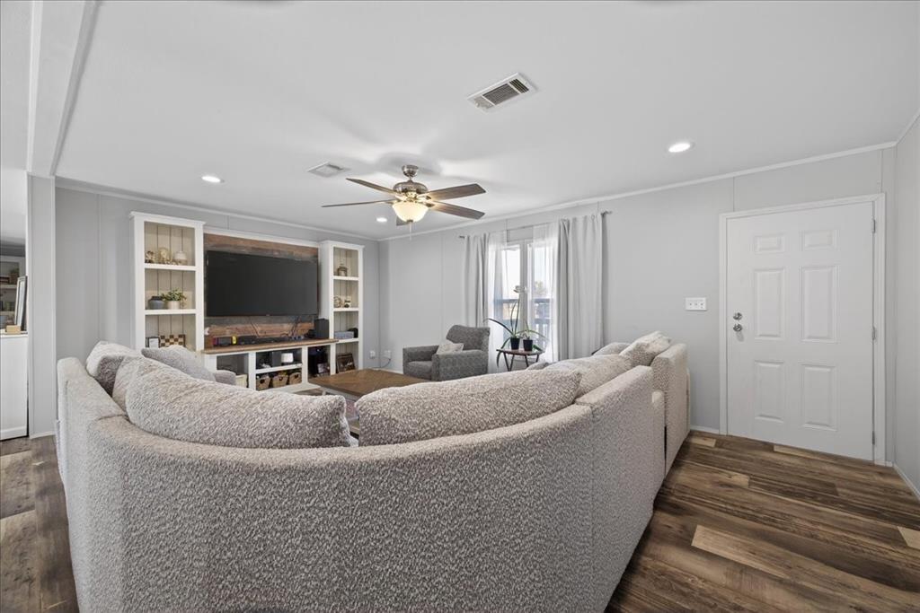 3605 Mockingbird Circle Cleburne, TX 76031 - Photo 10 of 40 Living area featuring dark wood-style floors, recessed lighting, ceiling fan, and ornamental molding