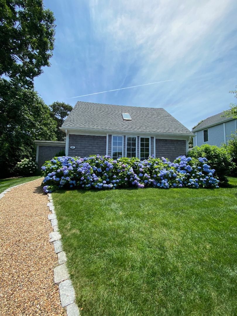 87 Schoolhouse Road Edgartown, MA 02539 - Photo 28 of 29 a front view of a house with a garden