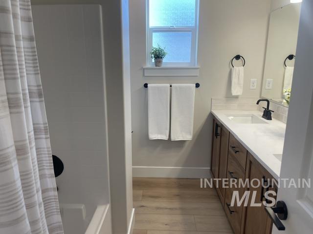 2035 Sumac Avenue Middleton, ID 83644 - Photo 12 of 17 Bathroom featuring a wood-finish vanity with a light-toned countertop, an undermount sink, and matte black fixtures