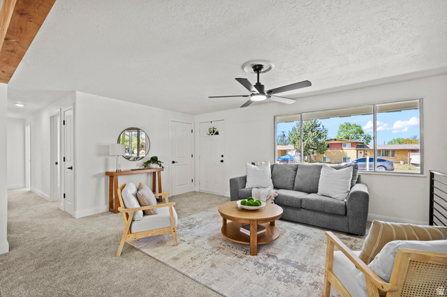 2267 West 4350th Street South Roy, UT 84067 - Photo 7 of 32 Carpeted living room with a ceiling fan and a textured ceiling