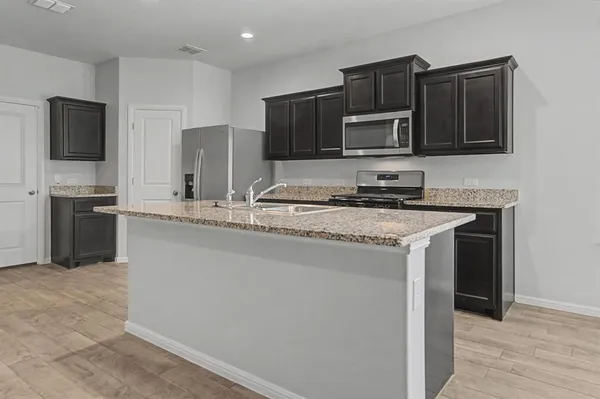 a kitchen with stainless steel appliances granite countertop a stove microwave and refrigerator