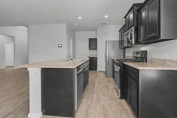 a kitchen with stainless steel appliances granite countertop a sink stove and refrigerator