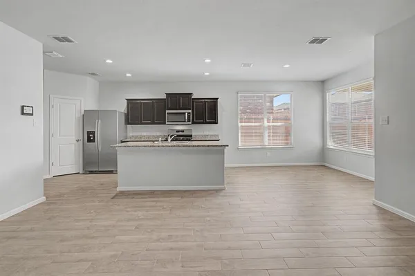 a kitchen with stainless steel appliances a refrigerator and a stove top oven