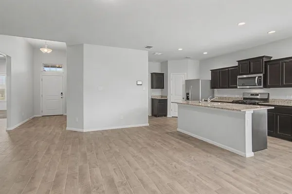 a kitchen with stainless steel appliances a refrigerator and a stove top oven