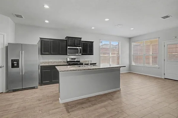 a kitchen with stainless steel appliances granite countertop a stove a sink and a refrigerator