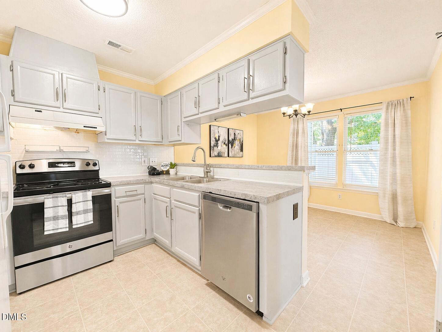 5010 Avenida Del Sol Drive Raleigh, NC 27616 - Photo 14 of 27 a kitchen with a stove a sink and a microwave