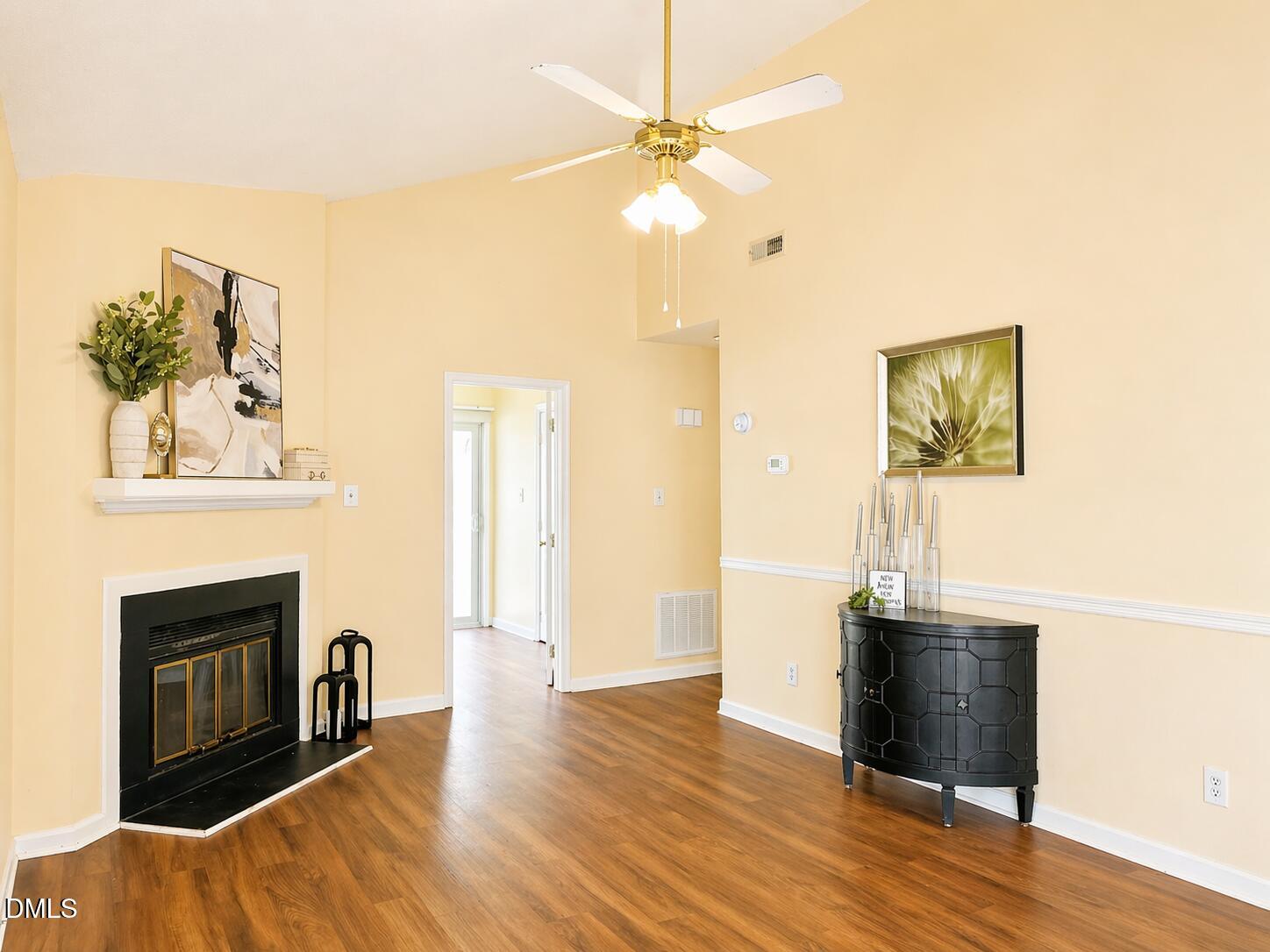 5010 Avenida Del Sol Drive Raleigh, NC 27616 - Photo 7 of 27 a view of a livingroom with a fireplace wooden floor and furniture