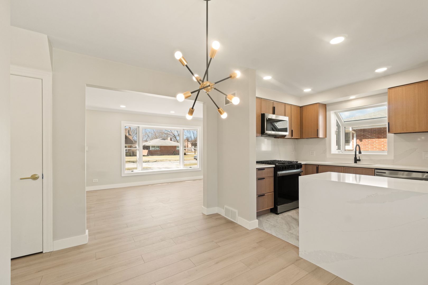 219 North Pine Street Mount Prospect, IL 60056 - Photo 5 of 20 a kitchen with stainless steel appliances granite countertop a refrigerator a sink dishwasher a stove and white countertops with wooden floor